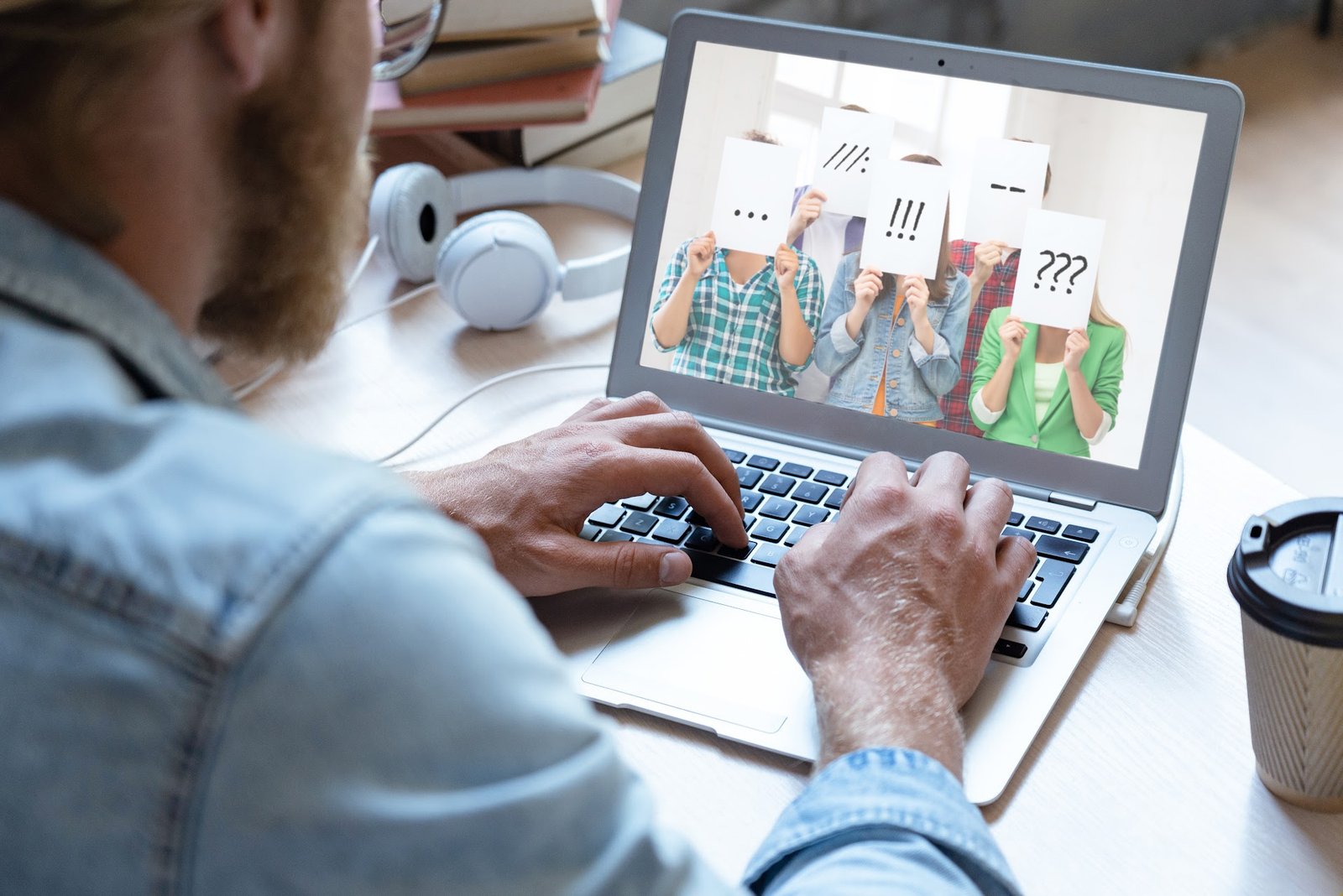 Person at laptop viewing a group holding punctuation marks over their faces, symbolizing uncertainty about audience identity and communication tone.