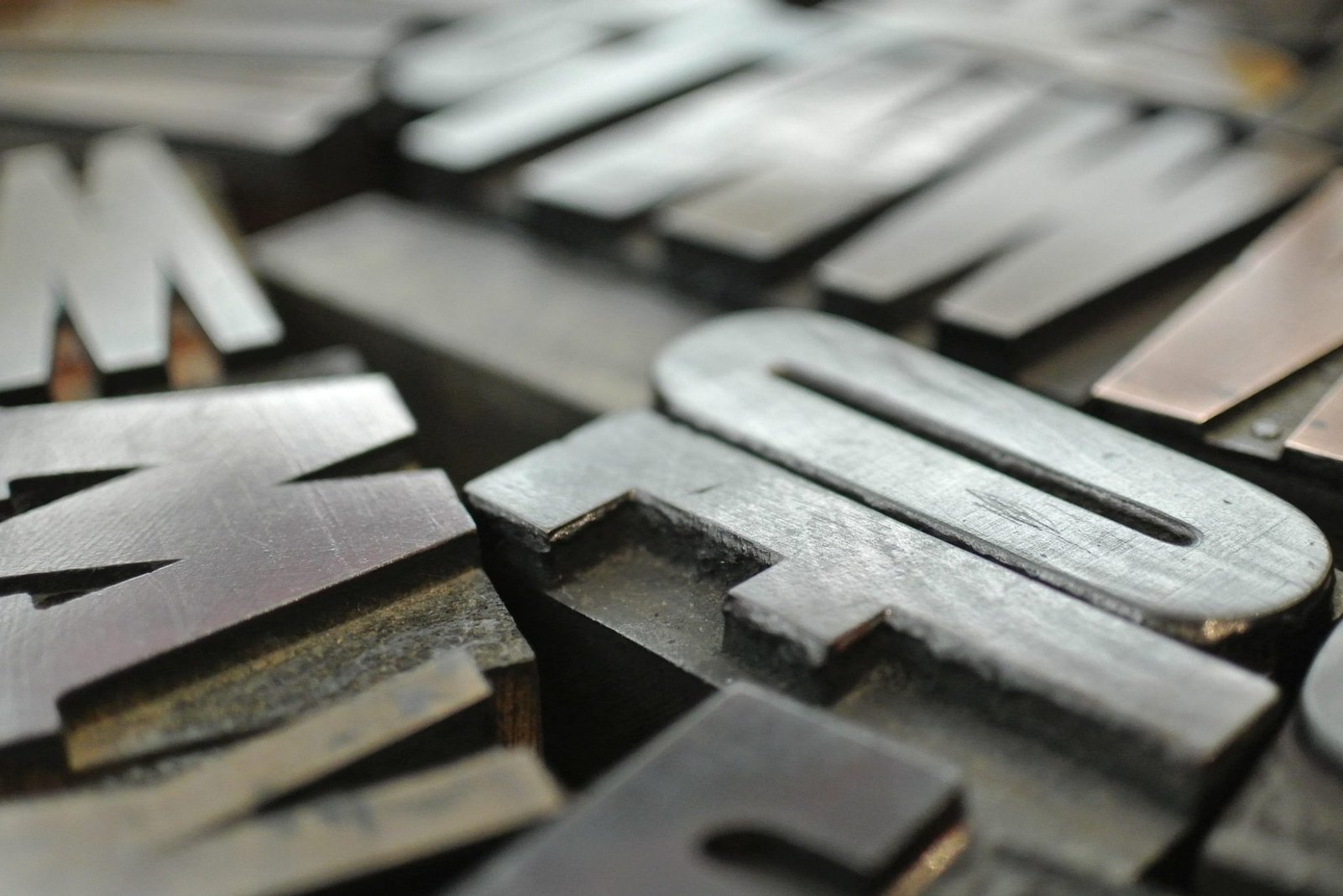 Close-up of metal printing press type, symbolizing the permanence and accountability of print communication