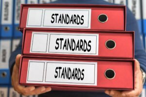 Red binders labeled “Standards” representing organized civic policies and documentation