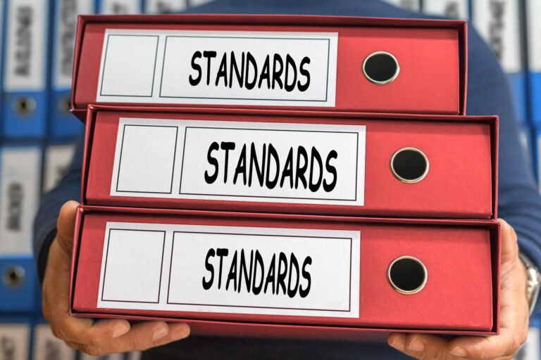 Red binders labeled “Standards” representing organized civic policies and documentation